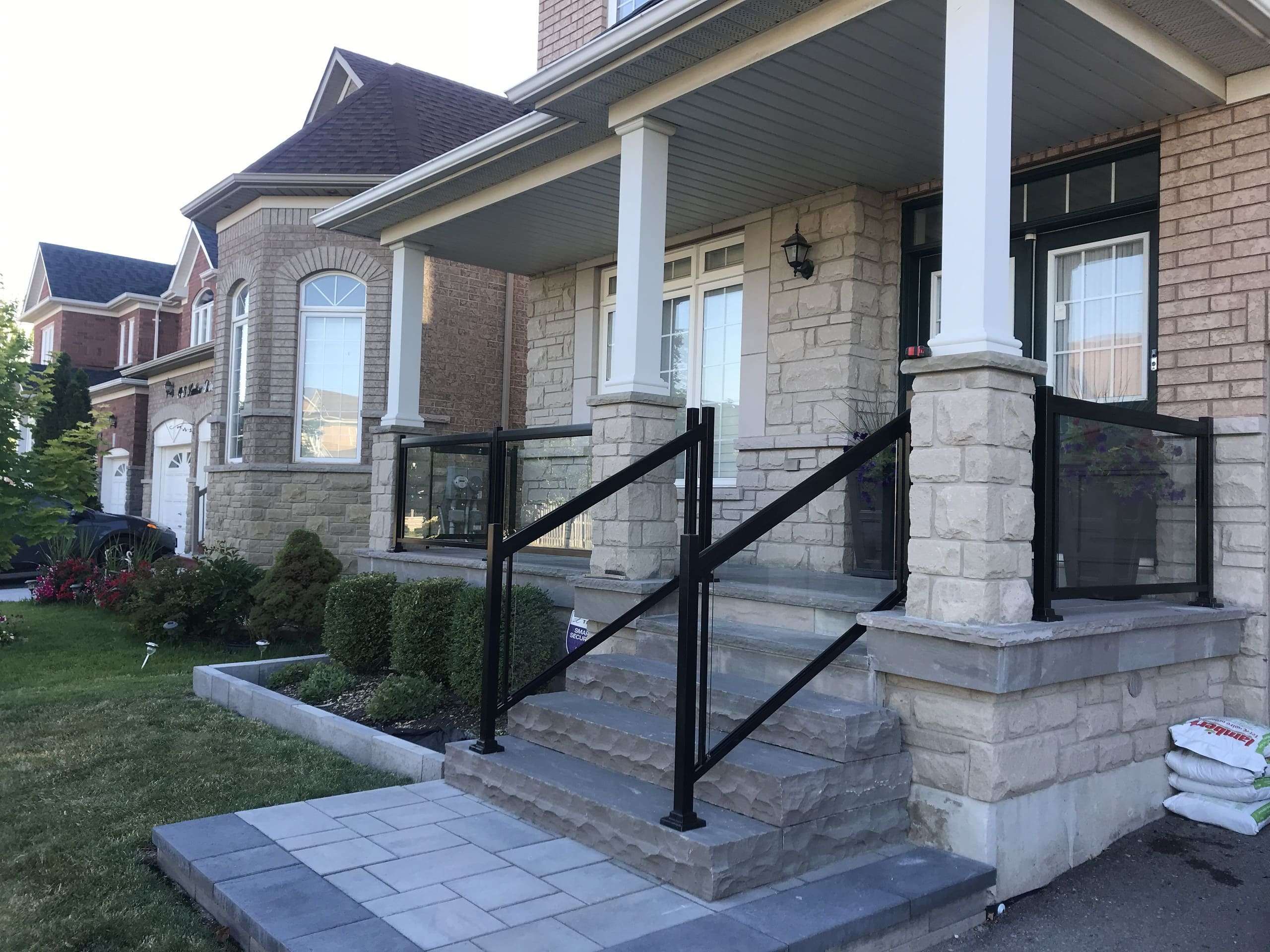Black Porch Railings Clear Glass Installation on Natural Stones (Milton, ON)